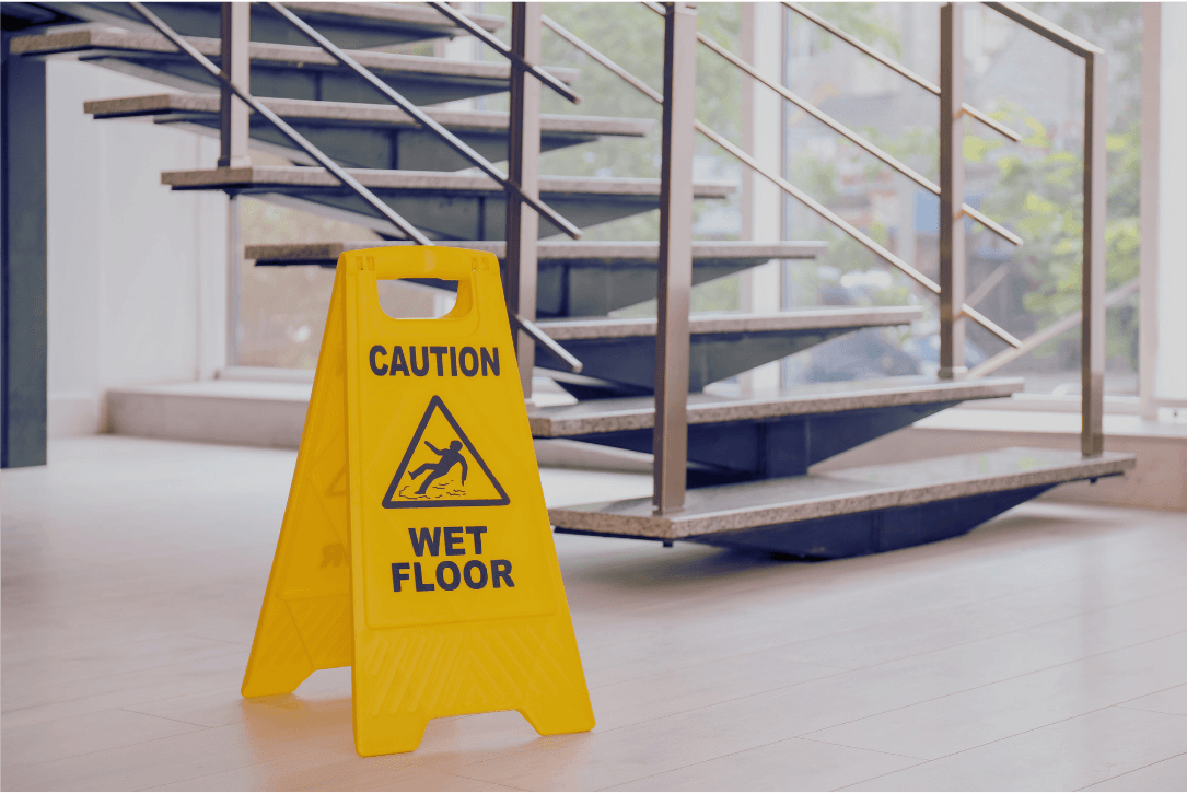 Treppenhausreinigung mit Warnschild für nassen Boden